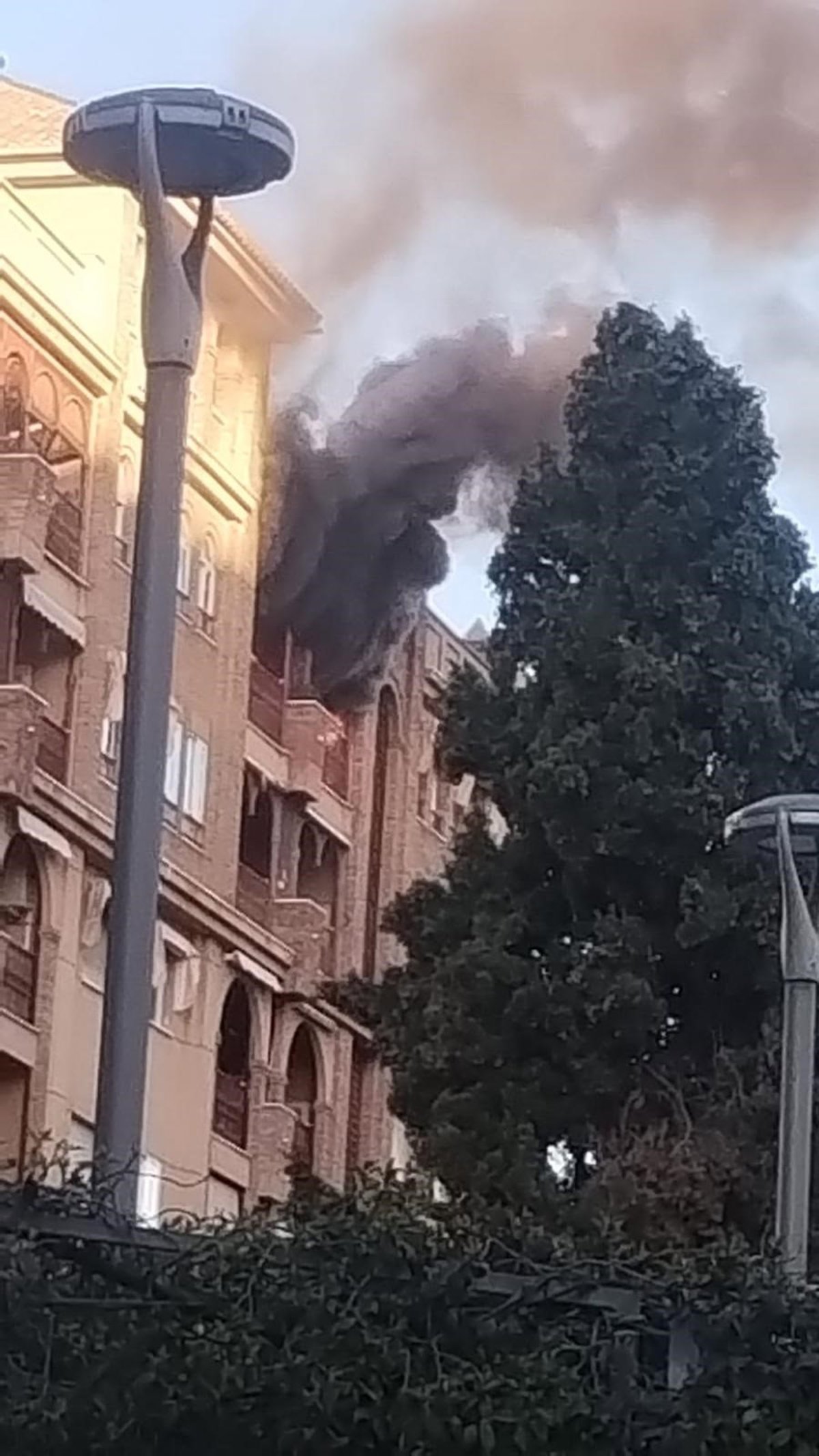 Bomberos extinguiendo llamas en la terraza de un ático en Granada con equipos de aire acondicionado dañados por el fuego