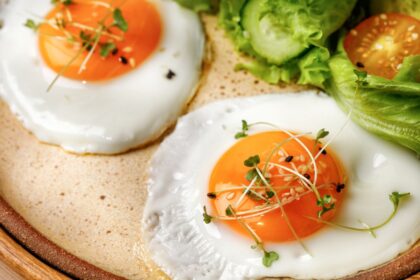 Huevos cocinados en sartén mostrando clara cuajada y yema líquida, técnica ideal para absorber su proteína al 100%