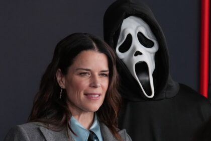 Cartel promocional de 'Scream 8' con Ghostface en un set de rodaje oscuro y la silueta de Neve Campbell al fondo