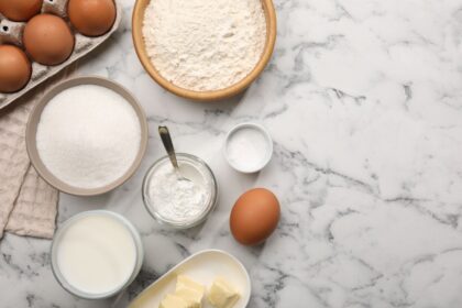 Ingredientes naturales para preparar polvo de hornear casero: bicarbonato, cremor tártaro y almidón sobre mesa de madera