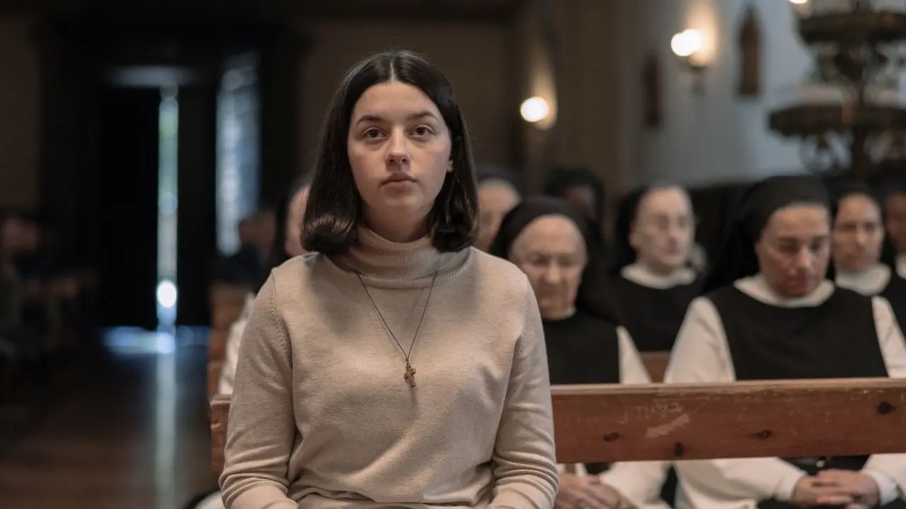 Blanca Soroa como Ainara en un fotograma intenso de 'Los Domingos', con hábito monástico y mirada decidida frente a un crucifijo