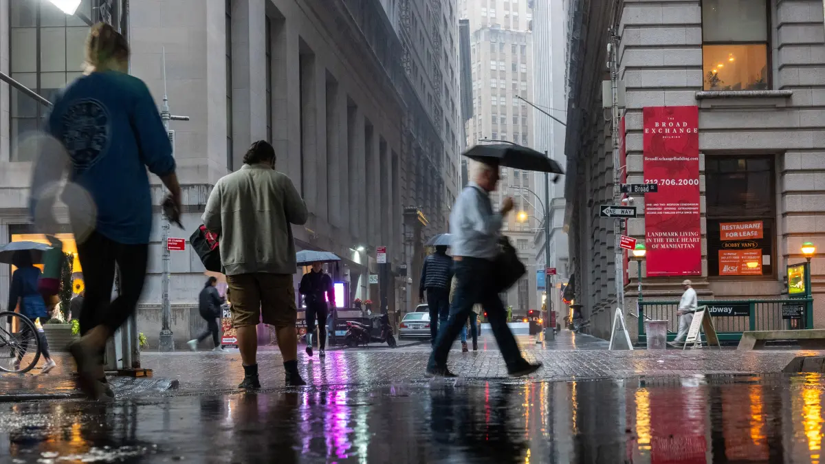 Persona caminando bajo la lluvia con paraguas, disfrutando los 5 beneficios científicos del petricor y los iones negativos que liberan estrés