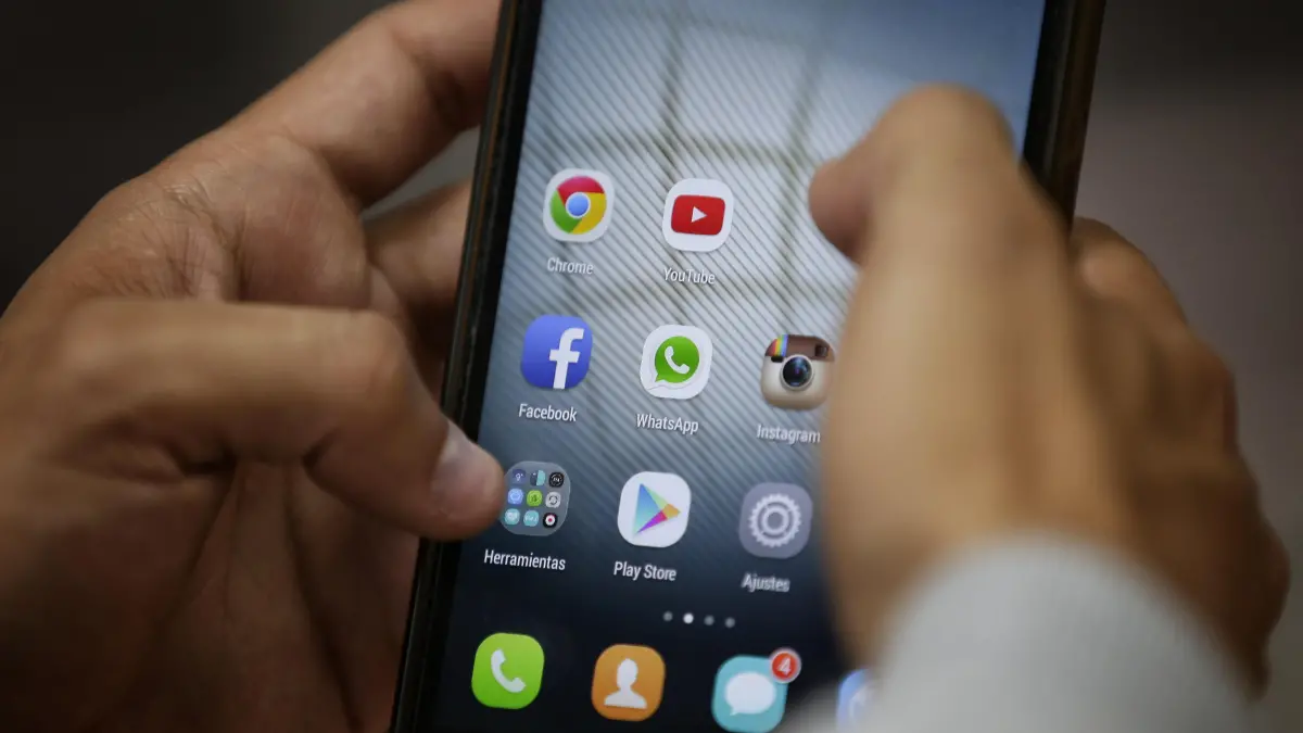 Persona usando smartphone 2026 con IA integrada y pantalla adaptable para trabajo y ocio sin interrupciones