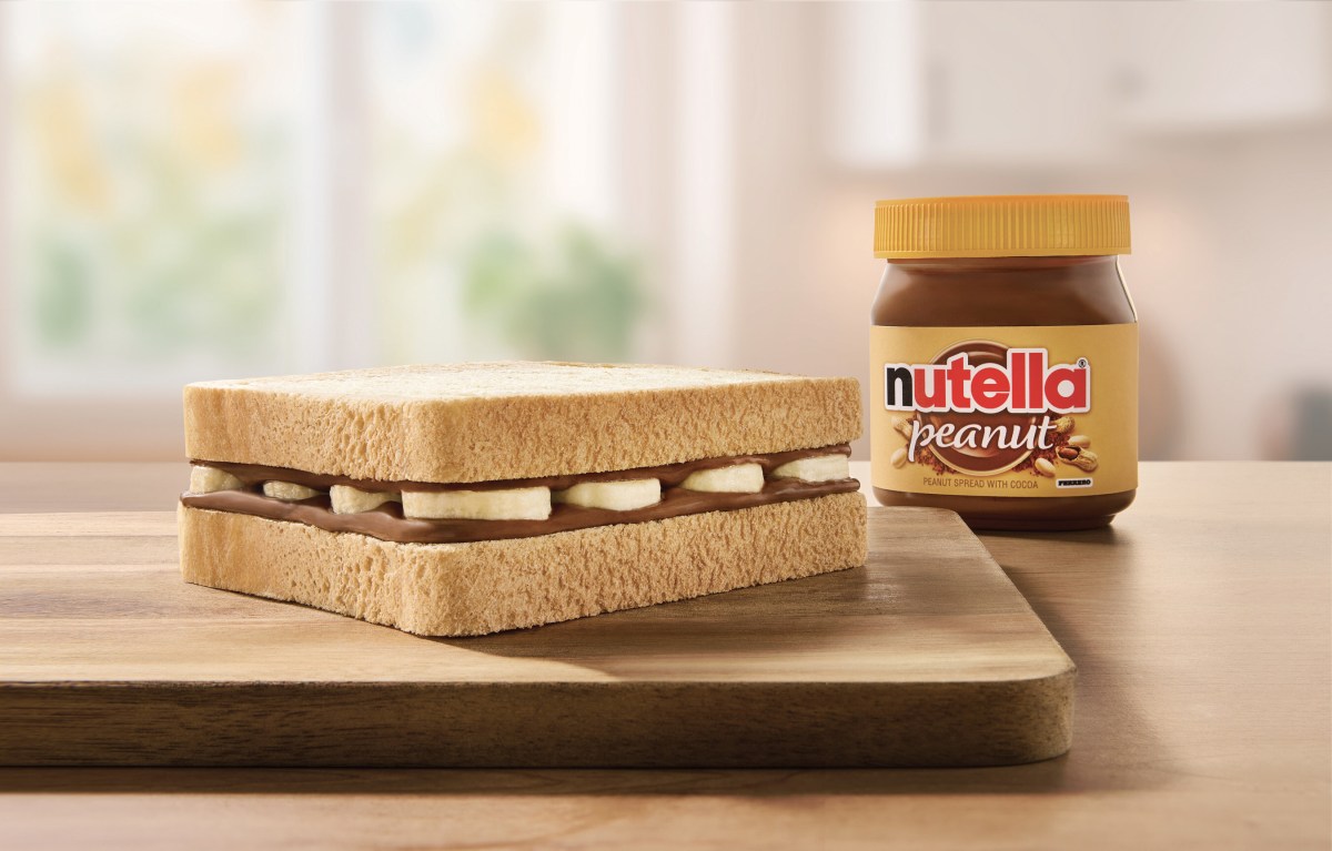 Tarros de Nutella Peanut con maní tostado sobre fondo rústico, mostrando la textura cremosa y trozos de cacahuete