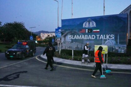 Reunión urgente de delegados de EEUU e Irán en Pakistán con documentos sobre la mesa y relojes marcando el plazo del 22 abril