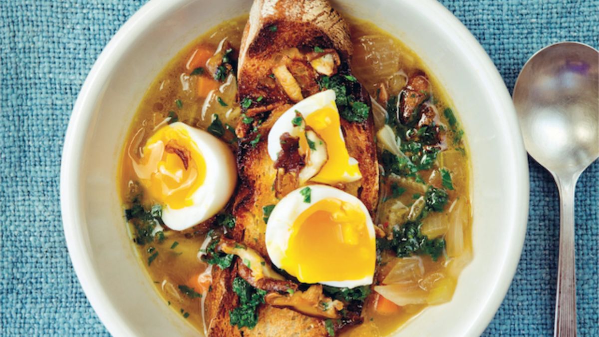 Sopa de shiitake con huevo cremoso de 6 minutos y perejil esmeralda escaldado, servida en bowl de cerámica con tallos de hongos tostados