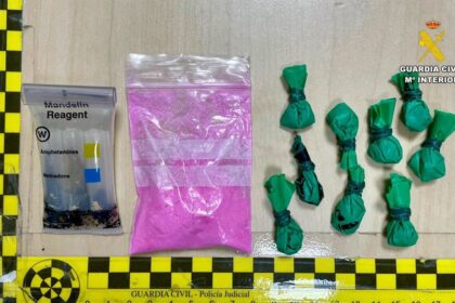 Agente de la Guardia Civil mostrando bolsitas con 'tusi' (cocaína rosa) incautadas en un control en Cáceres, con polvo rosáceo visible