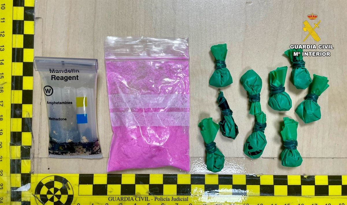 Agente de la Guardia Civil mostrando bolsitas con 'tusi' (cocaína rosa) incautadas en un control en Cáceres, con polvo rosáceo visible