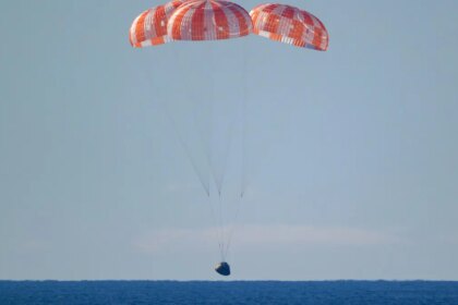 Cápsula Orión de Artemis II amerizando en el Pacífico tras misión lunar, con paracaídas desplegados y equipo de recuperación cerca
