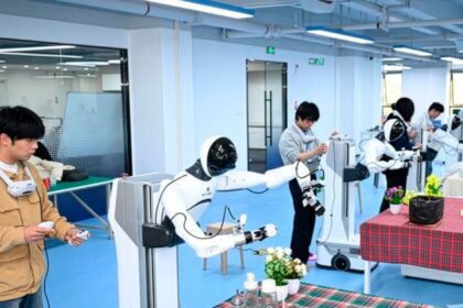 Robot humanoide en una 'escuela' de China practicando movimientos precisos con un vaso de papel bajo supervisión de operarios con realidad virtual