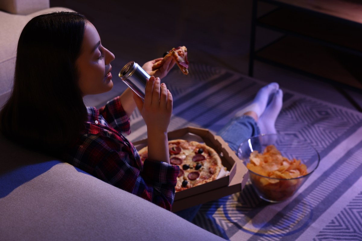 Reloj de arena con comida simbolizando cómo cenar tarde afecta el ritmo circadiano y la salud del colon