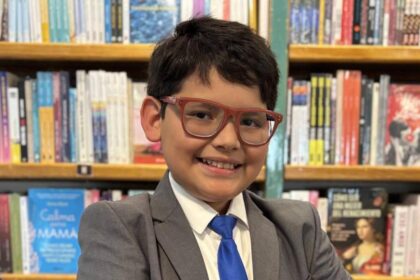 Niño mexicano de 10 años con CI de 162 sonríe frente a un pizarrón con ecuaciones y dibujos de Leonardo da Vinci