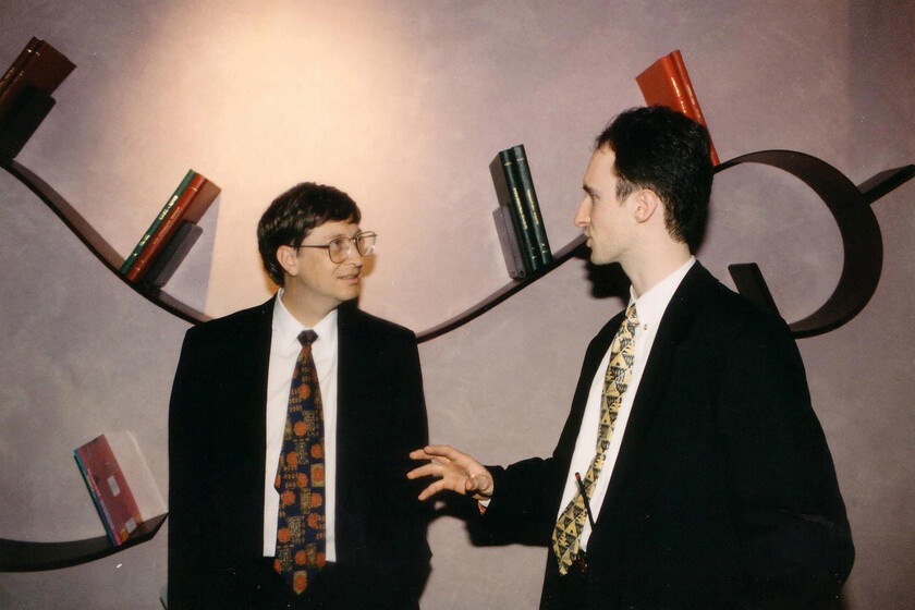 Ingenieros discutiendo frente a un teclado vintage con la tecla Tab resaltada, símbolo del conflicto IBM-Microsoft en los 80