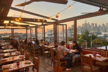 Interior de Alma en Brooklyn con mesas de madera y decoración que mezcla lo rústico y moderno, destacando platillos como enchiladas con mole amarillo