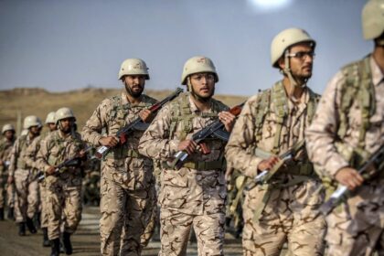 Soldados iraníes en posición de combate con el lema 'dedo en el gatillo' durante alerta máxima frente a posible ataque de EEUU en 2024