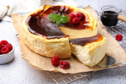 Cheesecake proteico recién horneado con toppings de frutos rojos frescos y mermelada sin azúcar, listo para desayunar