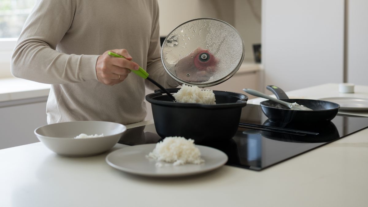 Plato de arroz cocido con termómetro marcando 20°C junto a reloj de arena de 2 horas como recordatorio del límite seguro antes de refrigerar
