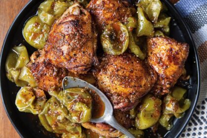 Muslos de pollo dorados con piel crujiente bañados en aderezo rojo de chiles guajillo y tomatillos asados, servidos en molcajete de piedra volcánica