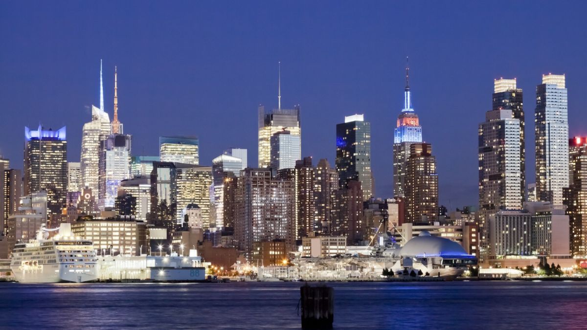 Proyección de 'Top Gun' (1986) en la cubierta del portaaviones USS Intrepid con el skyline de Manhattan iluminado al fondo y aviones históricos alrededor