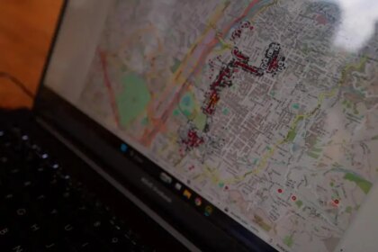 Persona en silla de ruedas usando el mapa digital Pendiente Cero en una calle de Medellín con señalización táctil y rampas accesibles