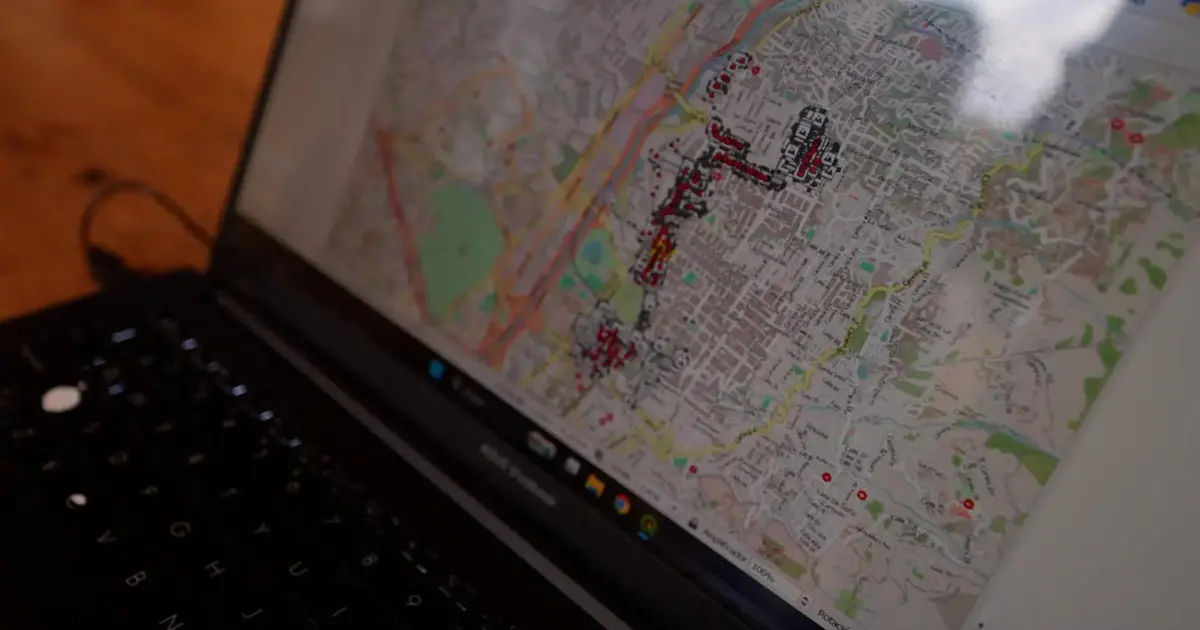 Persona en silla de ruedas usando el mapa digital Pendiente Cero en una calle de Medellín con señalización táctil y rampas accesibles