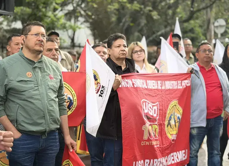 Trabajadores de Ecopetrol en planta petrolera discutiendo proyectos de fracking con mapas de yacimientos en Colombia