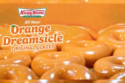 Docena de donas Orange Dreamsicle con glaseado naranja y vainilla sobre fondo veraniego brillante