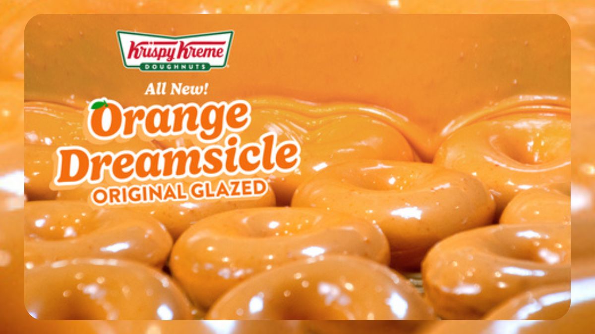 Docena de donas Orange Dreamsicle con glaseado naranja y vainilla sobre fondo veraniego brillante