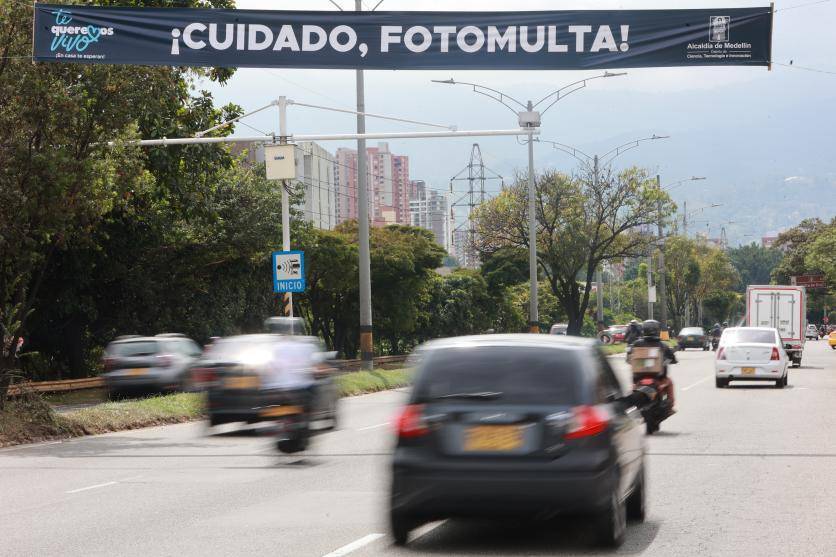 Conductor revisando en su computador la lista de fotomultas anuladas por MinTransporte con comprobante de pago en mano