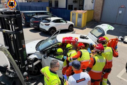 Carretilla industrial de 2 toneladas con pala metálica incrustada en el asiento de un coche tras accidente laboral en Valencia