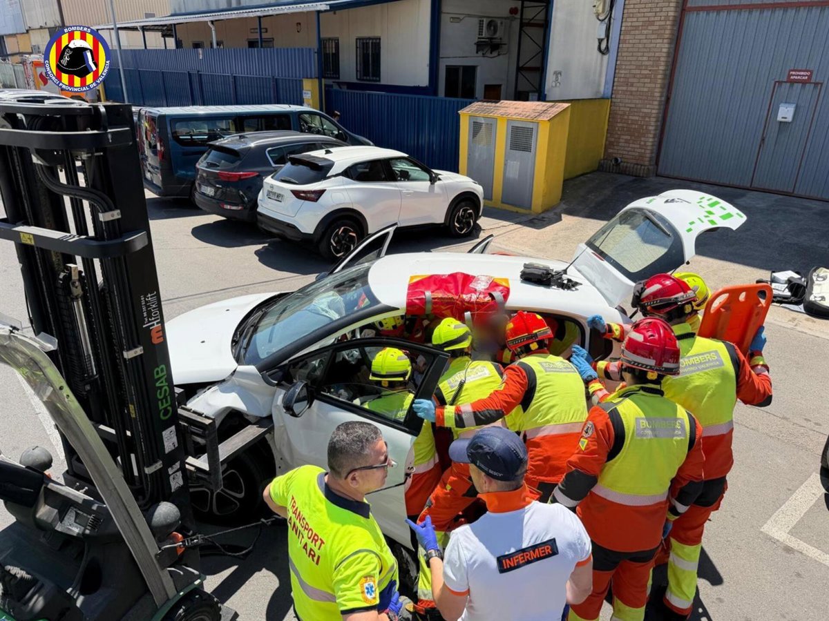Carretilla industrial de 2 toneladas con pala metálica incrustada en el asiento de un coche tras accidente laboral en Valencia