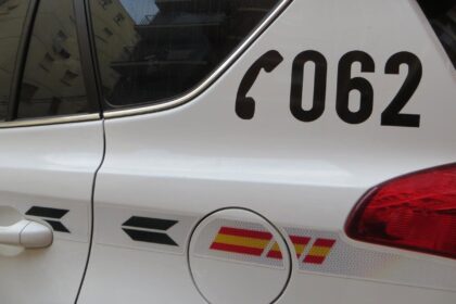 Agente de la Guardia Civil mostrando tarjetas bancarias y un patinete eléctrico incautados tras estafas contactless en Mogán