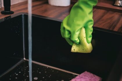 Primer plano de una bandeja de escurridor con restos orgánicos y gotas de agua estancada, foco invisible de bacterias como E. coli en la cocina