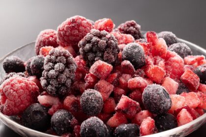Fresas rojas brillantes sobre bandeja de aluminio lista para congelación rápida, manteniendo su textura original sin cristales de hielo