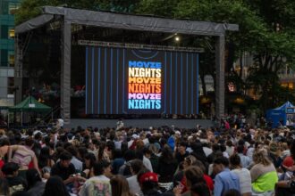 Multitud viendo película al aire libre en Bryant Park con el cartel de Paramount+ Movie Nights