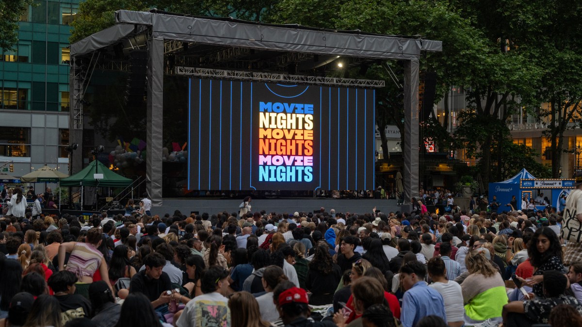Multitud viendo película al aire libre en Bryant Park con el cartel de Paramount+ Movie Nights