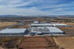 Parque industrial en Querétaro con imponentes centros de datos de AWS y Microsoft, rodeados de tierras agrícolas en contraste con la infraestructura tecnológica