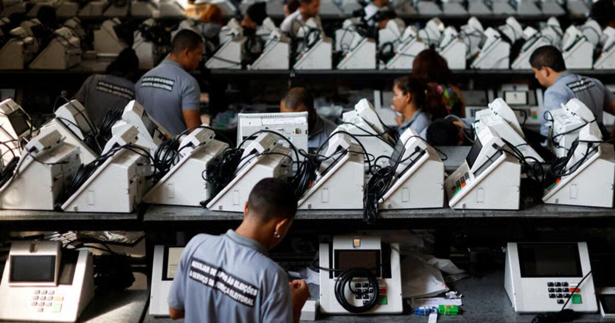 Técnico del TSE revisa una urna electrónica brasileña con pantalla táctil y lector de huellas, símbolo de 30 años sin fraudes comprobados