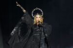 Madonna en pleno concierto sorpresa en Times Square 2024, rodeada de fans bajo las pantallas gigantes con luces neón