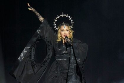 Madonna en pleno concierto sorpresa en Times Square 2024, rodeada de fans bajo las pantallas gigantes con luces neón