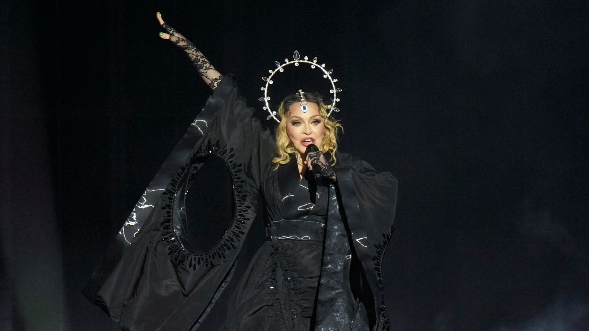 Madonna en pleno concierto sorpresa en Times Square 2024, rodeada de fans bajo las pantallas gigantes con luces neón
