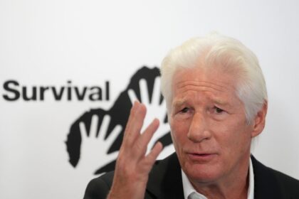 Richard Gere con gesto serio durante discurso en Premios Havel 2025 en Oslo, señalando con la mano mientras critica a Trump como 'peligro global'