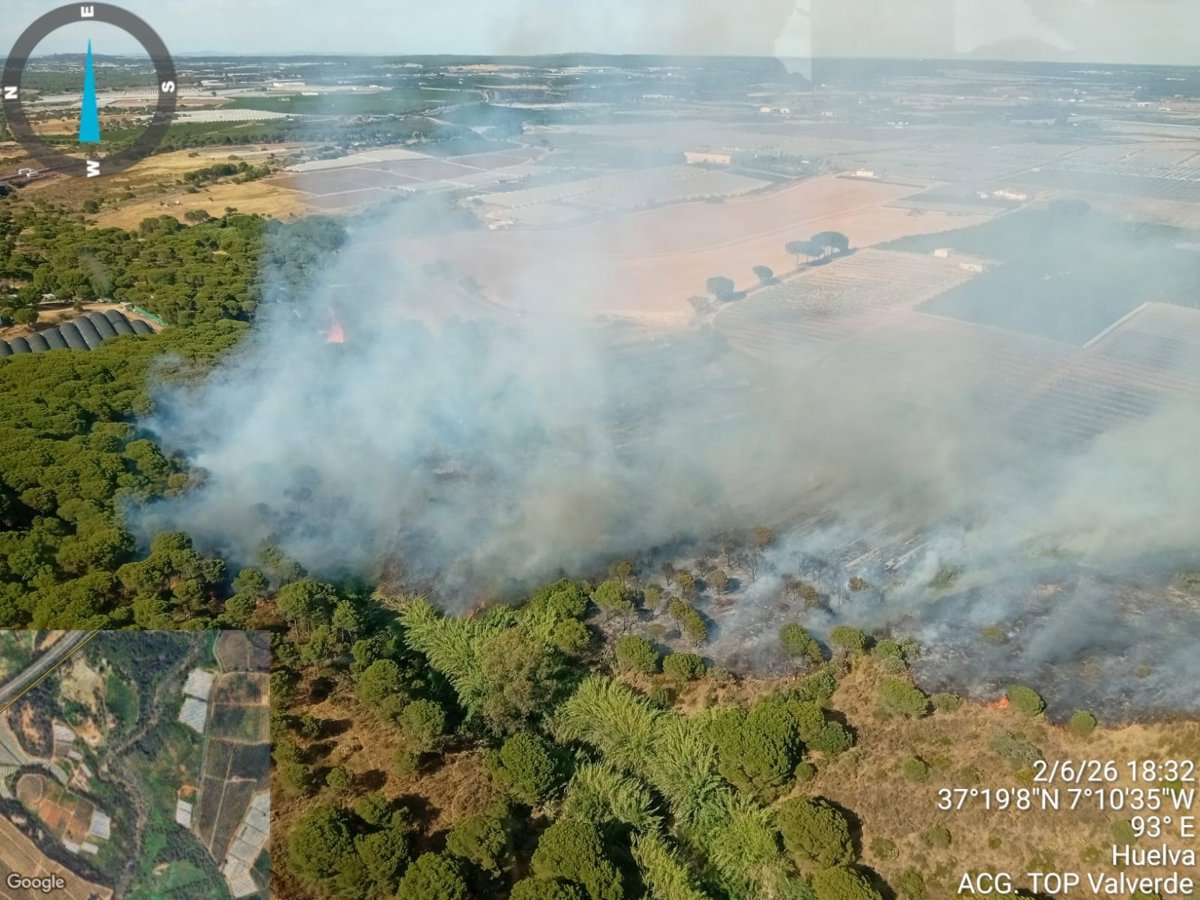 Aviones anfibios del Infoca descargando agua sobre el incendio forestal en Tariquejo, Huelva, con humo denso y vegetación ardiente