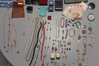 Agente de policía deteniendo a mujer acusada de robar joyas a anciana en Sevilla