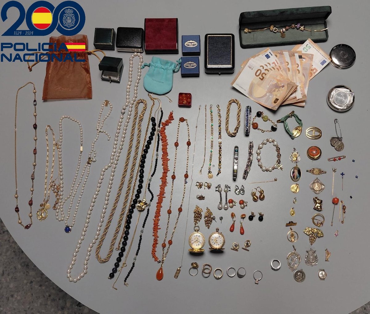 Agente de policía deteniendo a mujer acusada de robar joyas a anciana en Sevilla