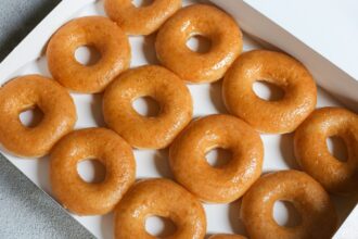 Docena de donas glaseadas de Krispy Kreme con decoración temática del Mundial 2026