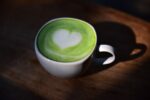 Taza de té verde con hojas frescas y antioxidantes visibles