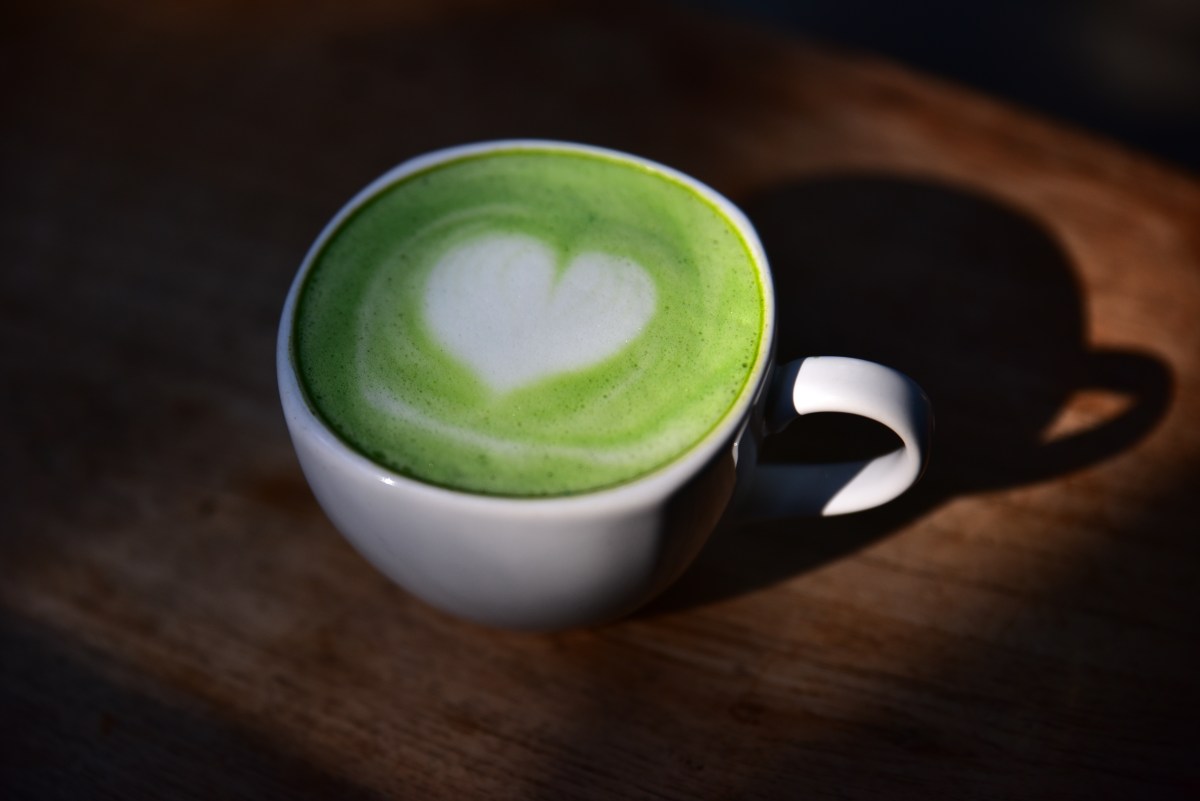 Taza de té verde con hojas frescas y antioxidantes visibles